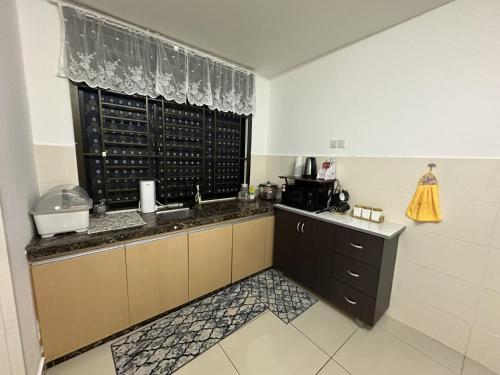 a kitchen with a counter with a sink and a window at DesaruHomestay92 in Bandar Penawar
