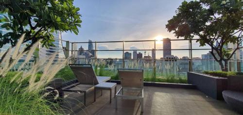 a balcony with two chairs and a view of a city at Sivatel Bangkok Hotel in Bangkok