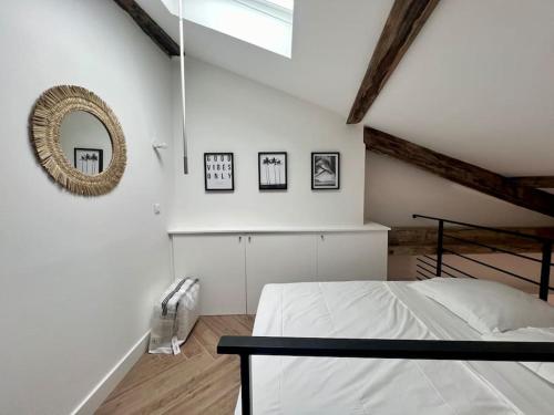 une chambre blanche avec un lit et un miroir dans l'établissement Casaflora - Le Corner Montpellier, à Montpellier