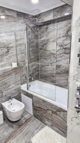 a bathroom with a bath tub and a sink at AIRPORT 24&24 CAR PARKING in Chişinău