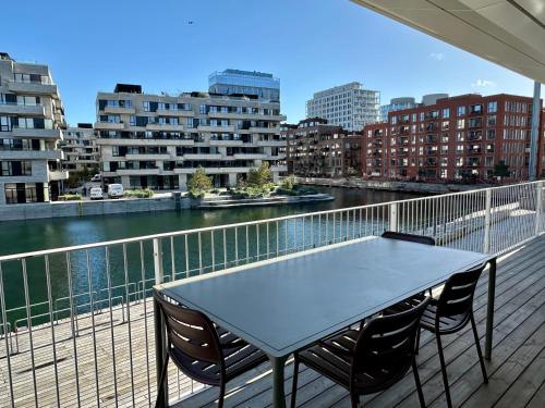 a table and chairs on a balcony with a view of a city at STAY Nordhavn in Copenhagen