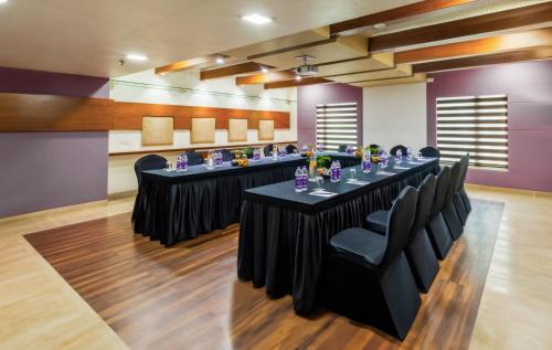 a meeting room with a long table with black chairs at Sayaji Pune in Pune