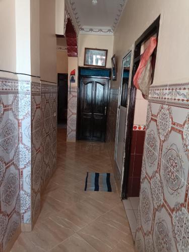 a hallway with a door in a room with tiles at ras el ma in Chefchaouene