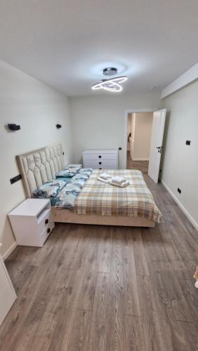 a bedroom with a bed and a wooden floor at AIRPORT 24&24 CAR PARKING in Chişinău