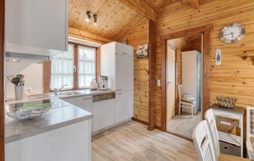 a kitchen with white appliances and a wooden wall at Ferienhaus Neckar 38 in Hayingen