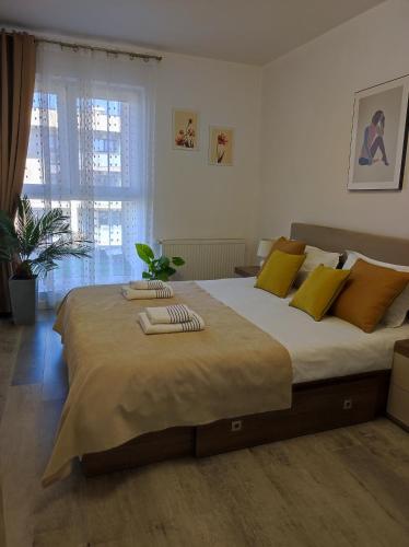 a bedroom with a large bed with yellow pillows at grand hill panorama in Cluj-Napoca