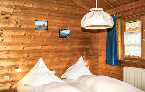 Schlafzimmer mit Holzwänden und einem Bett mit Kissen in der Unterkunft Ferienhaus Tauber 98 in Hayingen