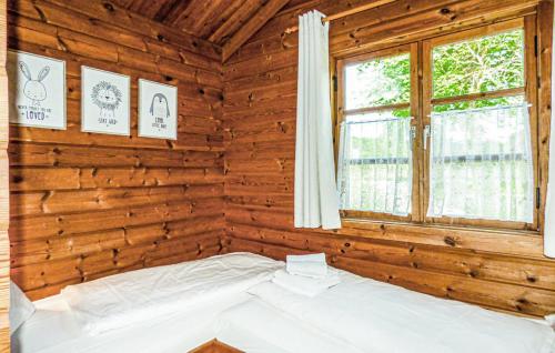 Bett in einem Holzzimmer mit Fenster in der Unterkunft Ferienhaus Neckar 7 in Hayingen