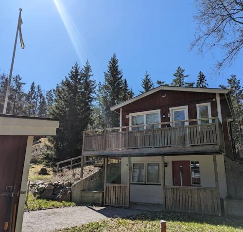 a large house with a large deck on top of it at A Tiny House in Norrby in Lanna-Drevviken