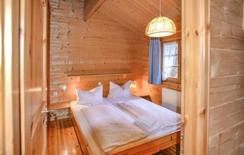 a bedroom with a bed in a wooden cabin at Ferienhaus Tauber 60 in Hayingen