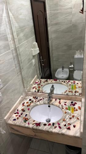 a bathroom with a sink with flowers on it at Sharah Mountains Hotel in Wadi Musa