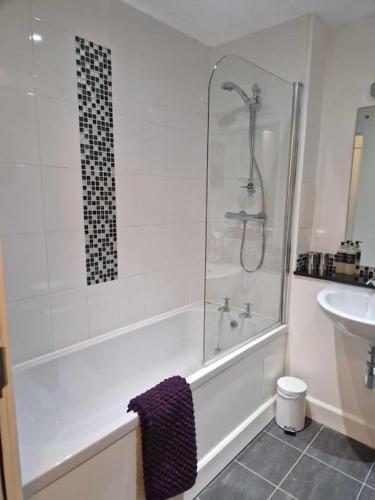 a bathroom with a shower and a tub and a sink at Glen Mor Apartment with pool on site in Fort Augustus