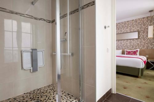 a bathroom with a shower and a bedroom with a bed at Le Marceau Bastille in Paris