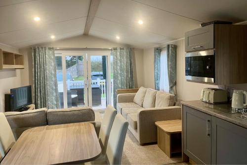 a living room with a couch and a table at Surfside Bliss - Cayton Bay Park caravan in Scarborough