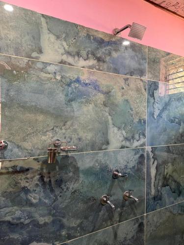 a painting on the wall of a bathroom with water at Livin Gokarna Beach Stay in Gokarn