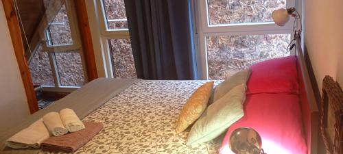 a bedroom with a bed with pillows and a window at KosmeEtxea, la casa del Parque EBI727 in Bermeo