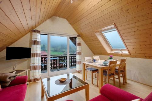 a living room with a table and chairs and a large window at Grundhof in Oberprechtal