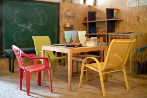 a classroom with colorful chairs and a table and a chalkboard at Grundhof in Oberprechtal