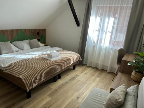 a bedroom with a large bed and a window at Penzion Aurelia Donovaly in Donovaly