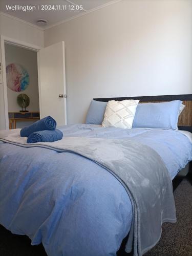 a large blue bed with two blue pillows on it at Comfy & Sunny home in Wellington--3 Heat Pumps in Wellington