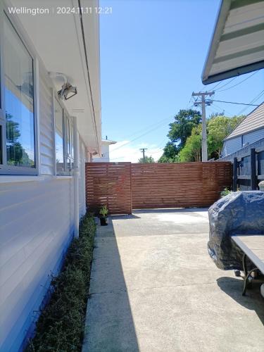 a sidewalk next to a house with a fence at Comfy & Sunny home in Wellington--3 Heat Pumps in Wellington