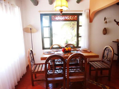 a dining room table with chairs and a window at Cabaña la Cattleya de Villa de Leyva in Villa de Leyva