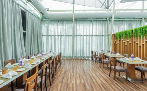 a dining room with long tables and chairs at Sayaji Pune in Pune
