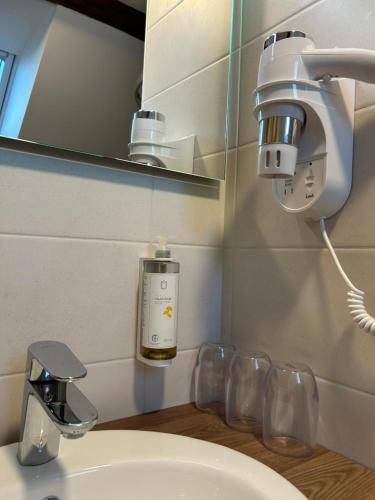 a bathroom with a sink and a light and a mirror at Penzion Aurelia Donovaly in Donovaly
