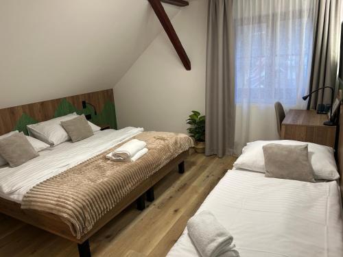 a bedroom with two beds and a window at Penzion Aurelia Donovaly in Donovaly