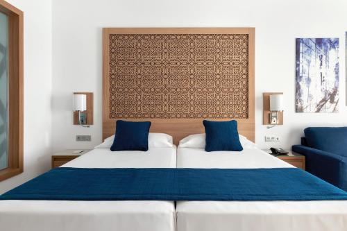 a bedroom with two beds with blue pillows at Hotel Riu Palace Boavista - All Inclusive in Boa Ventura
