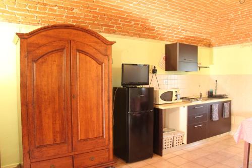 a kitchen with a black refrigerator with a tv on top at La Rosa dei Venti in Parella