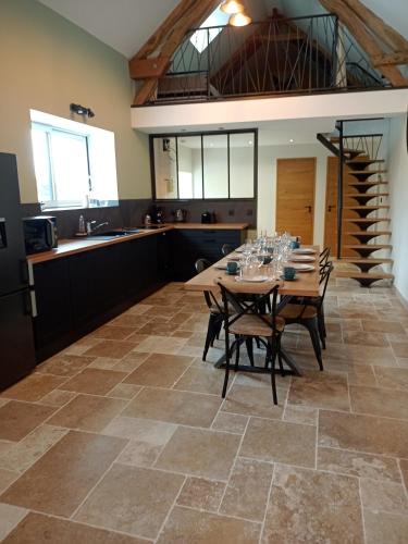 une cuisine et une salle à manger avec une table et des chaises dans l'établissement Gîte 2 de l être aux rues, à Marmouille