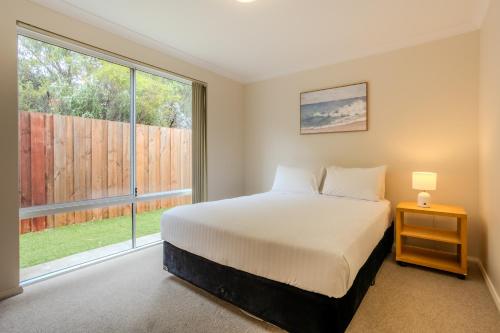 a bedroom with a bed and a large window at Albany Bayside by the BnB Collection in Albany