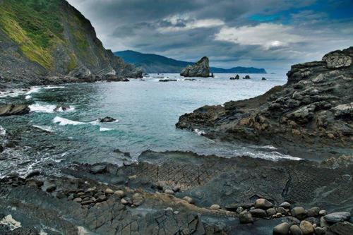 a large body of water with rocks in the ocean at KosmeEtxea, la casa del Parque EBI727 in Bermeo