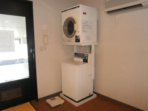 a washing machine sitting on top of a refrigerator at Hotel Route-Inn Kawaguchiko in Fujikawaguchiko