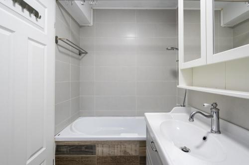 een witte badkamer met een bad en een wastafel bij Concept Studio Haven 19 in Boekarest