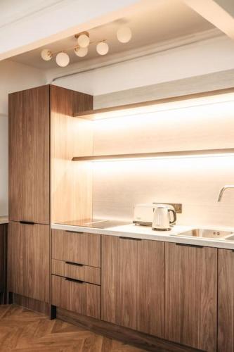 une cuisine avec des armoires en bois et un évier dans l'établissement Appartement de Luxe 6P - Muette Trocadero, à Paris