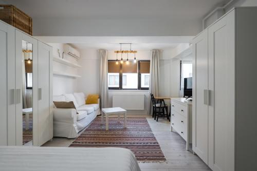 een woonkamer met een witte bank en een tafel bij Concept Studio Haven 19 in Boekarest
