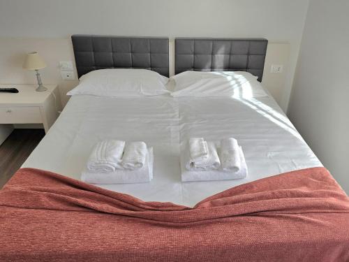 a white bed with two pairs of towels on it at Locanda al Sole - Vo' in Vo Euganeo