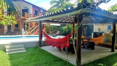 a hammock under a pergola next to a house at Casa Praia dos Anjos in Barra Grande