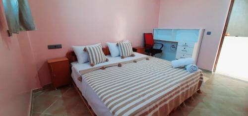 a bedroom with a bed with a dresser and a mirror at Azour House in Taghazout