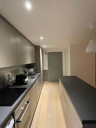 une cuisine avec un comptoir noir dans une pièce dans l'établissement Duplex les Myrtilles LES CARROZ centre station, aux Carroz d'Arâches