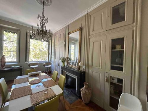 une salle à manger avec une table, des chaises et un lustre dans l'établissement Les 24 colonnes, à Lyon