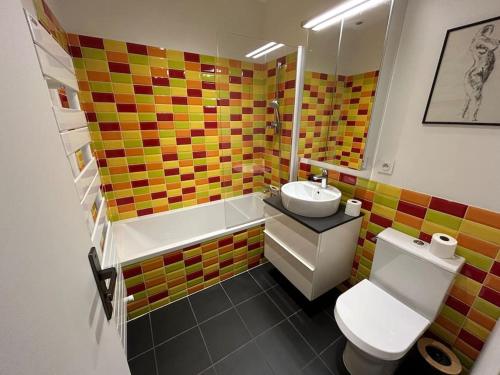 une salle de bain avec des toilettes blanches et un lavabo dans l'établissement Les 24 colonnes, à Lyon
