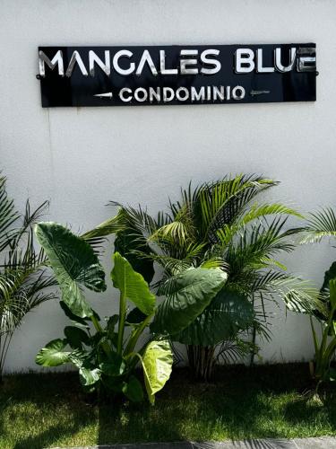 a sign on the side of a building with plants at Menacho Apartamento - Mangales Blue Norte in Santa Cruz de la Sierra