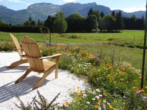 a wooden chair sitting in a field of flowers at Ferme de la grande Moucherolle in Villard-de-Lans