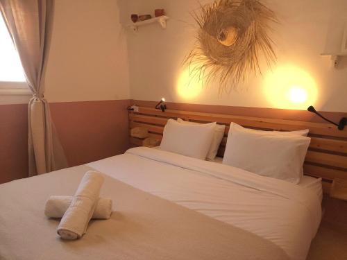 a bedroom with a large bed with white sheets and pillows at Tazuri Surf House in Taghazout