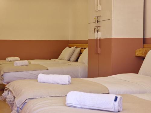 a room with three beds with towels on them at Tazuri Surf House in Taghazout