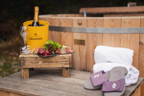 a table with a bottle of wine and a plate of food at Hotel Bad Ramsach in Läufelfingen