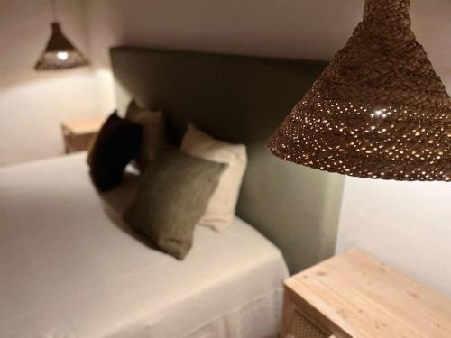 a bedroom with a bed with pillows and a lamp at Monte de Santa Rita in Évora Monte